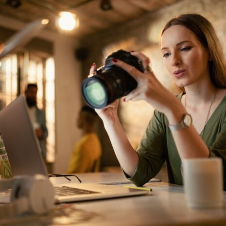 Female photographer checking images on digital camera in a studio.