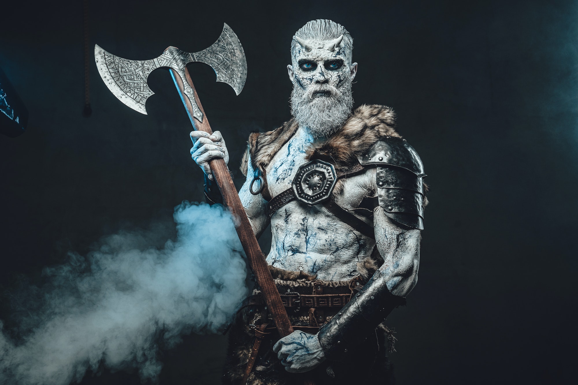 Savage dead warrior with huge axe in smokey dark background
